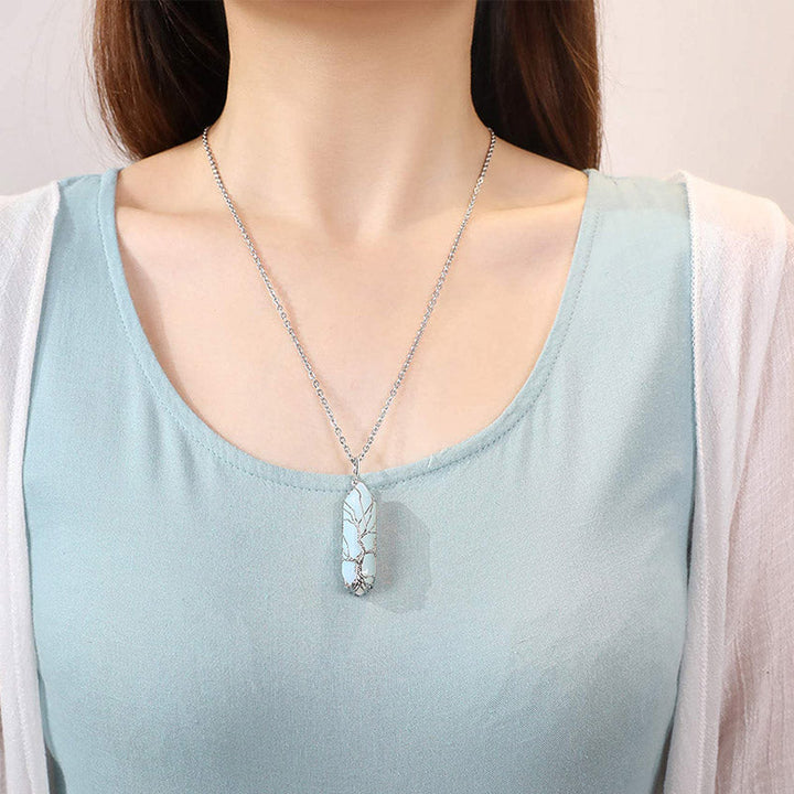 Frau mit türkisfarbenem Anhänger-Halskette, silberne Kette, elegantes Schmuckdesign.