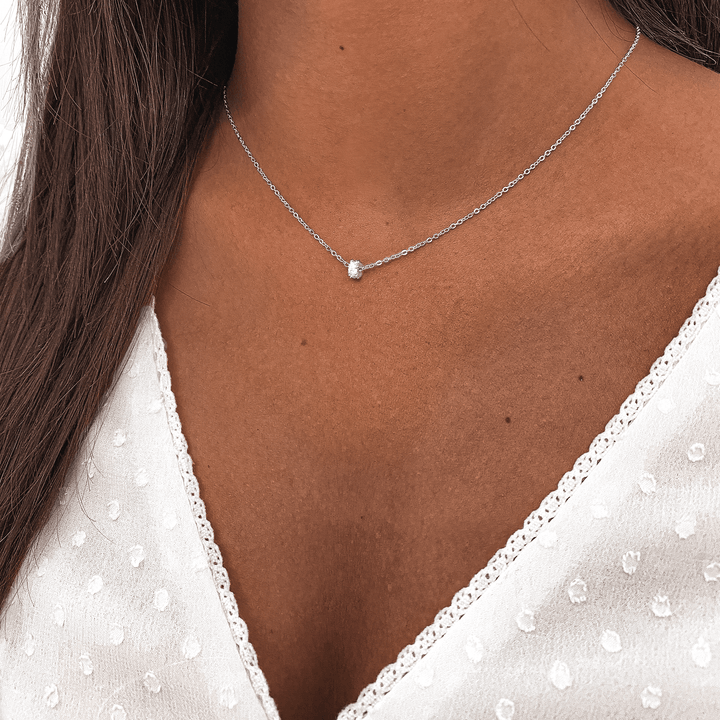 Silberne Halskette mit kleinem Anhänger, Damenmode, eleganter Schmuck, minimalistisches Design.