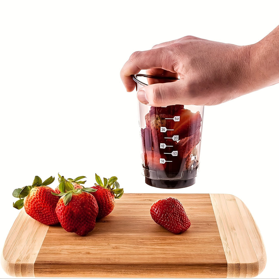 Hand hält Mixerbecher mit Erdbeeren auf Holzbrett, Küchenzubehör, Fruchtzubereitung.