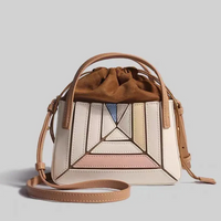Beige Lederhandtasche mit geometrischem Muster, verstellbarem Riemen, modisch und elegant.