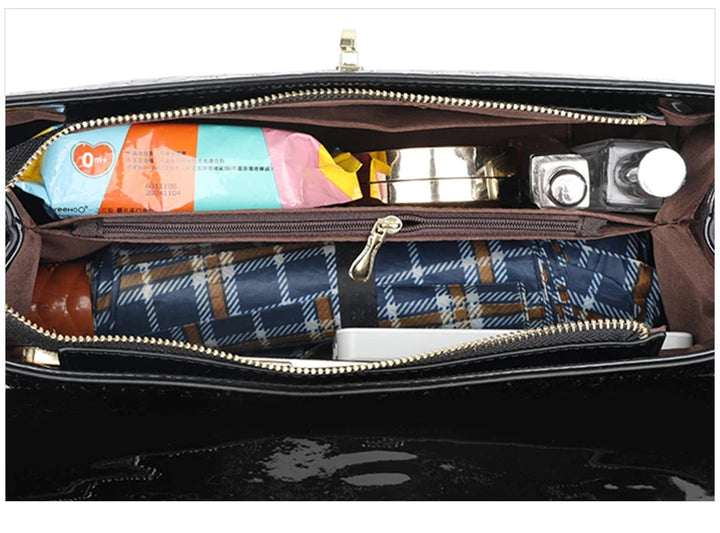 Schwarze Handtasche mit Reißverschluss, gefüllt mit Alltagsgegenständen, Innenansicht.