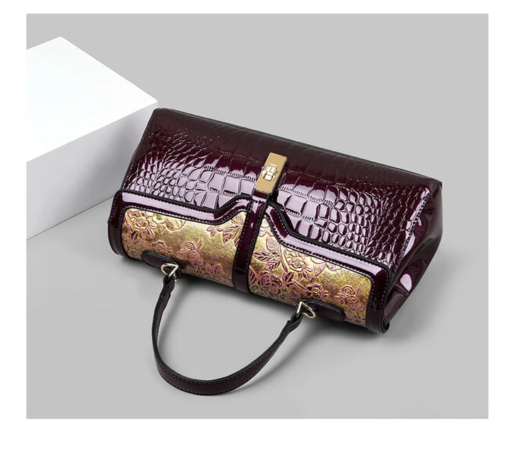 Luxuriöse Damenhandtasche aus Leder, burgunderrot mit goldener Stickerei, elegant und stilvoll.