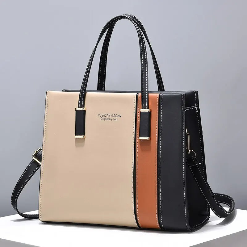 Damenhandtasche Leder beige schwarz braun, elegant, mit Tragegriff und Schulterriemen.