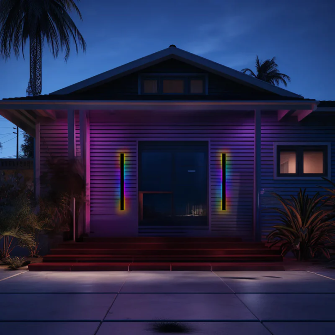 LED-Lichtleisten an Hausfassade bei Nacht, bunte Beleuchtung, moderne Außenbeleuchtung, Palmen.