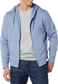 Mann in hellblauer Kapuzenjacke, grauem T-Shirt und Jeans, lächelnd, Freizeitmode.