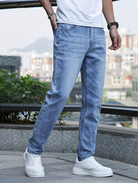 Mann in blauen Jeans und weißen Sneakers, urbaner Hintergrund, lässige Mode.