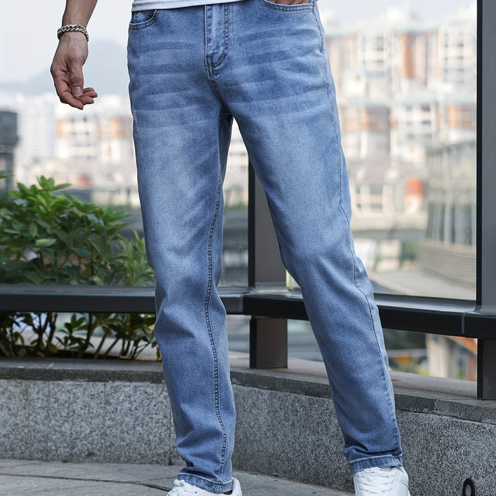 Mann in blauer Jeanshose, lässig, urbaner Hintergrund, modisch, Freizeitkleidung, Herrenmode.