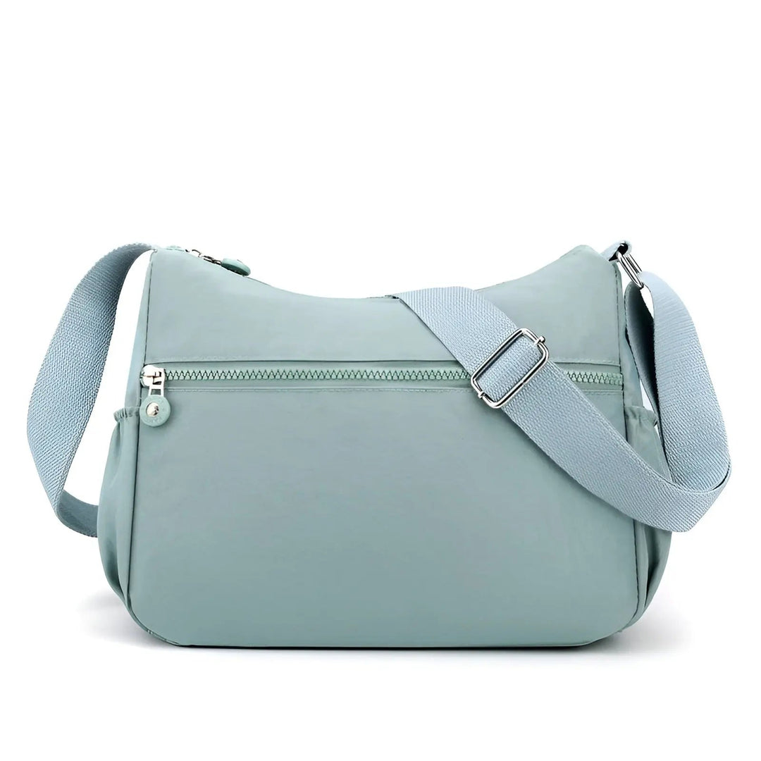Hellblaue Umhängetasche aus Nylon mit verstellbarem Gurt und Reißverschluss, modisch und praktisch.