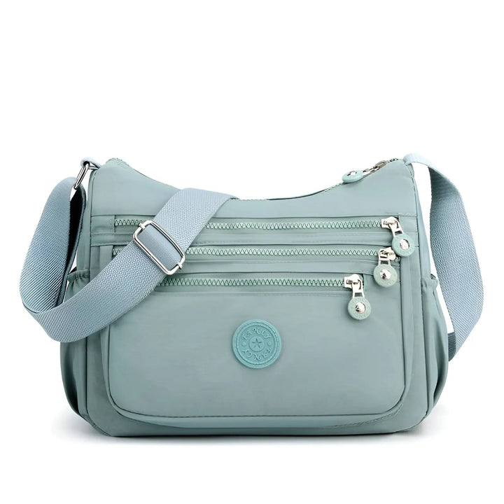 Hellblaue Umhängetasche mit Reißverschlüssen, verstellbarem Gurt, ideal für Damenmode.