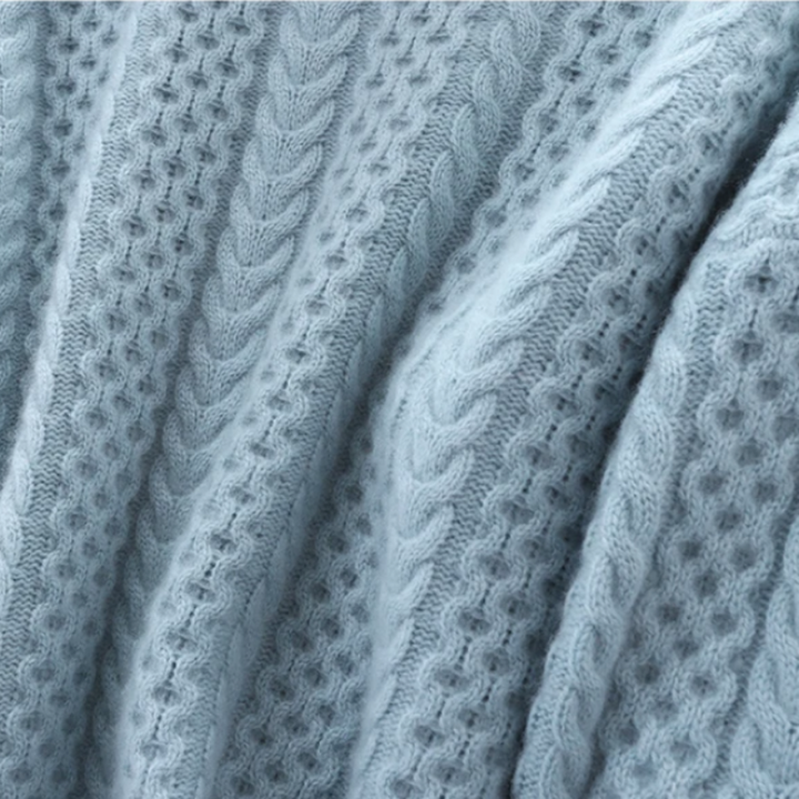 Hellblauer Strickstoff mit Zopfmuster, weiche Textur, ideal für Pullover und Wintermode.