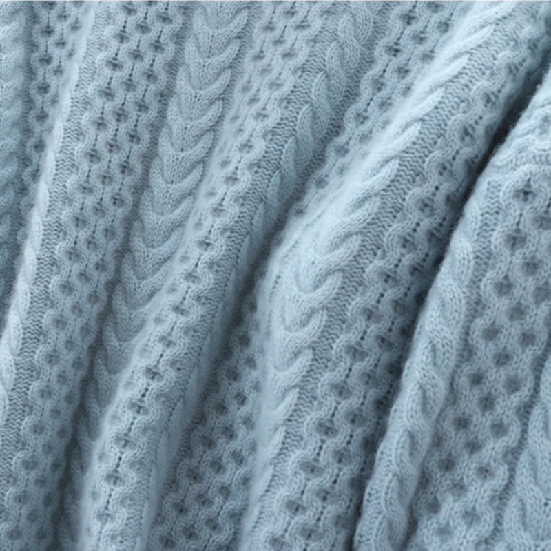 Hellblauer Strickstoff mit Zopfmuster, weiche Textur, ideal für Pullover und Wintermode.