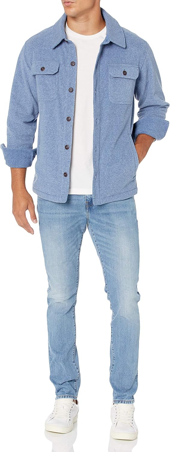 Mann in blauer Jeansjacke, weißem T-Shirt und hellblauer Jeans, lässiger Freizeitlook.
