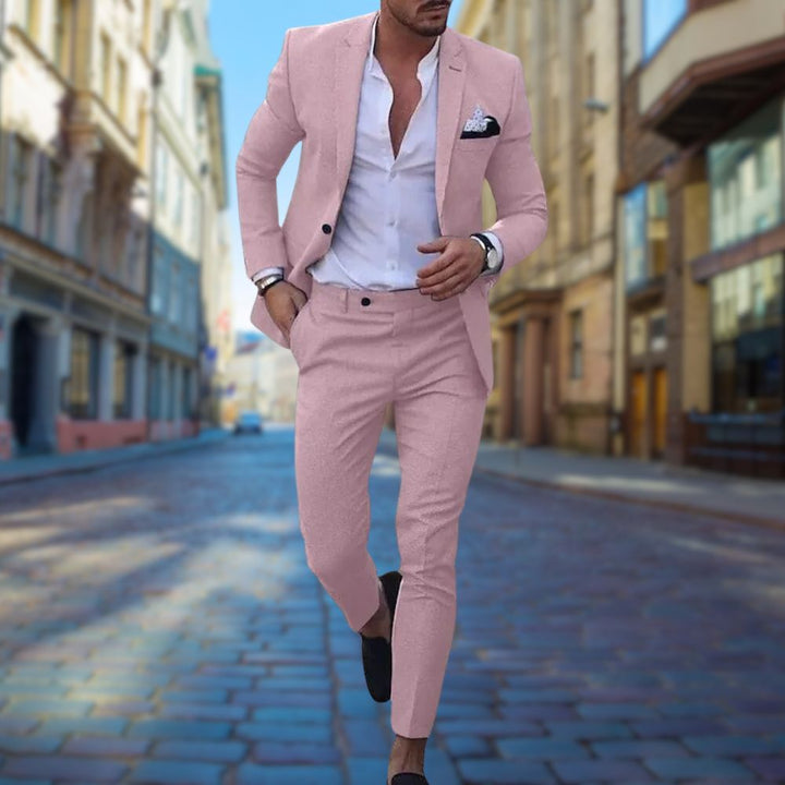 Mann im rosa Slim-Fit-Anzug auf Kopfsteinpflasterstraße, elegantes Herrenmode-Outfit.