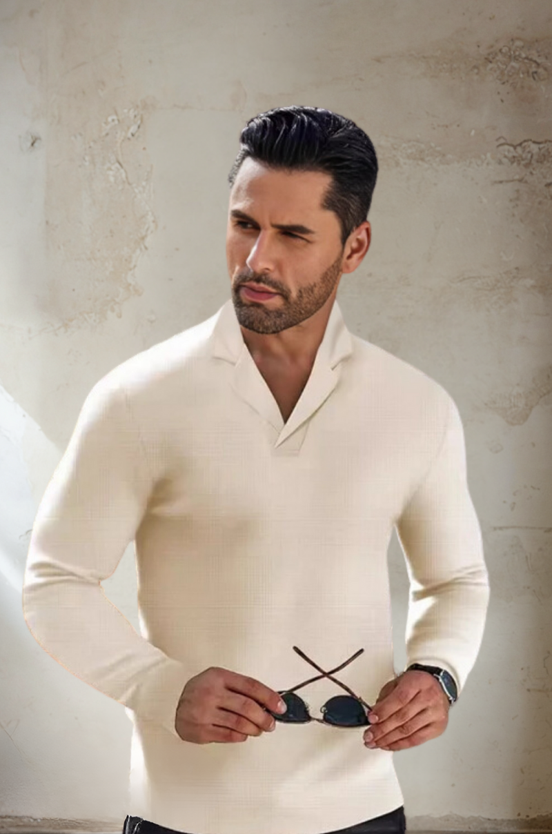 Mann in cremefarbenem Pullover hält Sonnenbrille, eleganter Look, Mode für Herren.