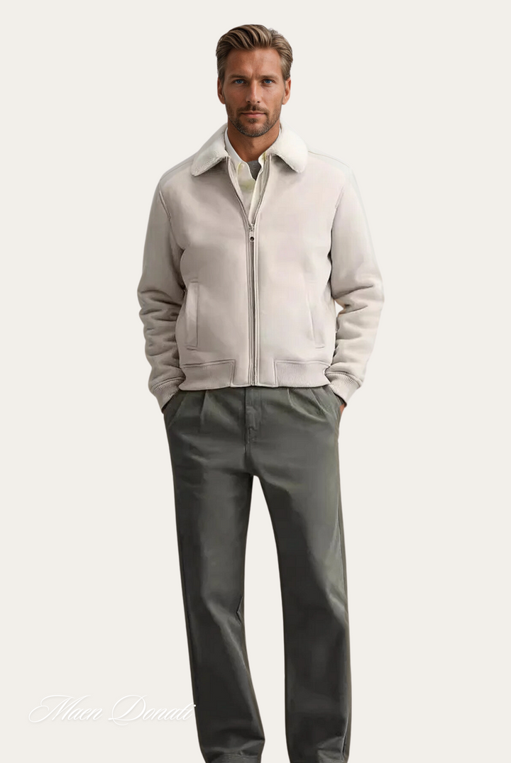 Mann in weißer Bomberjacke aus Leder, graue Hose, eleganter Look, Herrenmode, Herbstkollektion.