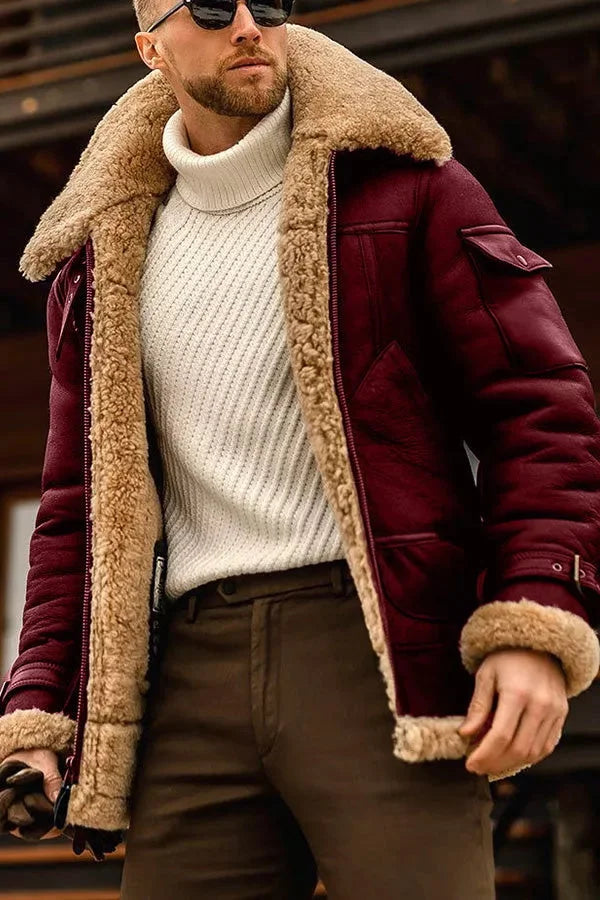 Mann in bordeauxroter Lederjacke mit Lammfellfutter, weißem Rollkragenpullover, braune Hose.