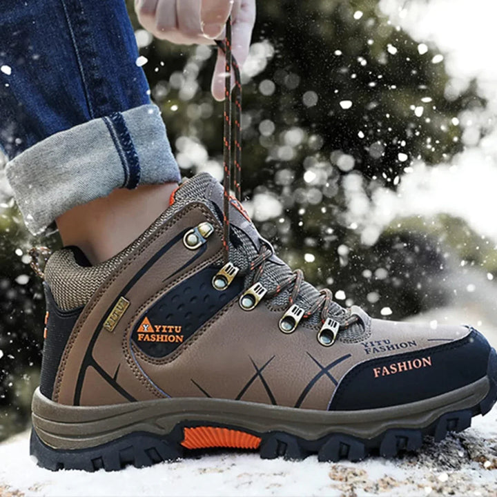 Wasserdichter brauner Wanderschuh, robustes Design, ideal für Outdoor-Aktivitäten im Schnee.
