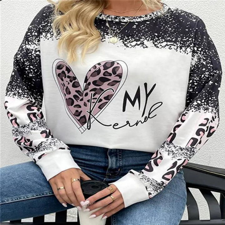 Frau trägt schwarz-weißes Sweatshirt mit Herz-Print und Leopardenmuster, lässige Mode.