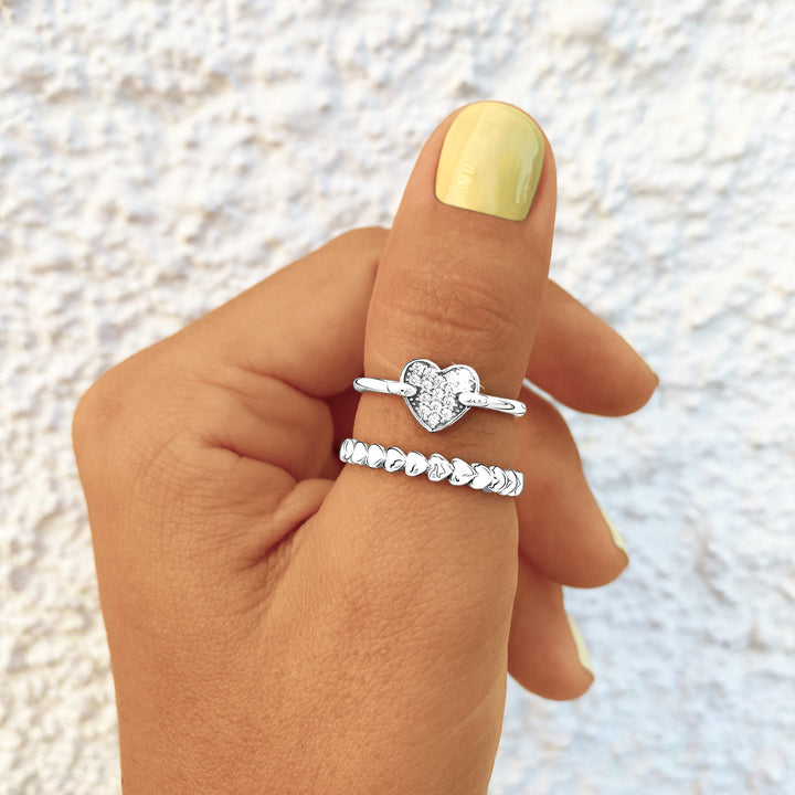 Silberringe mit Herzdesign, Damenmode, Schmuck, eleganter Stil, Nahaufnahme, Hand, Nagellack.