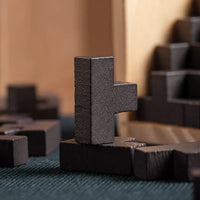 Schwarzes Holzpuzzle, Tetris-Form, auf blauem Stoff, Nahaufnahme, Spielzeug, Denkspiel.