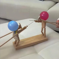 Holzspielzeug Fechtfiguren mit blauen und roten Helmen auf weißem Sofa, interaktives Design.