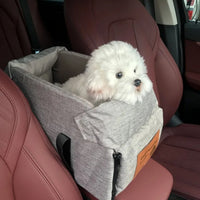 Weißer Hund in grauem Autositz für Haustiere, sicherer Transport, bequem, Autozubehör.