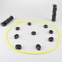 Schwarze Steine im Kreis mit gelbem Seil, auf grauem Hintergrund, Meditations-Set.