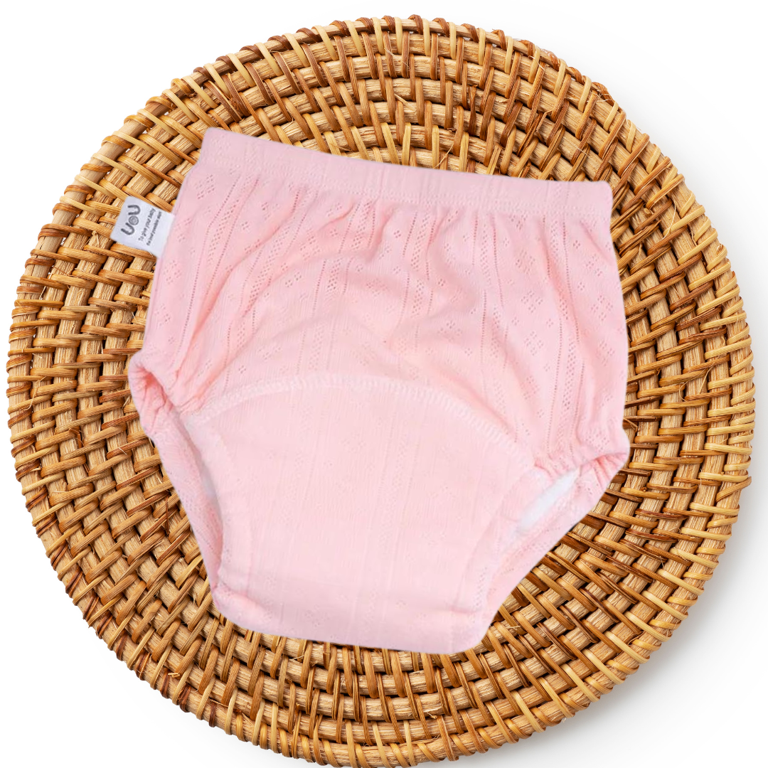 Rosa Baby-Unterhose aus Baumwolle auf geflochtenem Korb, atmungsaktiv, bequem.