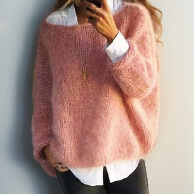 Frau trägt rosa Strickpullover, weißes Hemd, schwarze Hose. Modetrend, Damenbekleidung, Herbst.