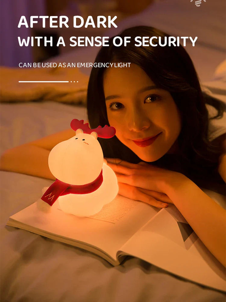 Frau mit Rentier-Nachtlicht auf Bett, warmes Licht, Notlicht, gemütliche Atmosphäre.