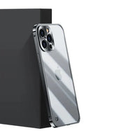 Silbernes Smartphone mit Dreifachkamera und Apple-Logo, schräg an schwarzer Box gelehnt.