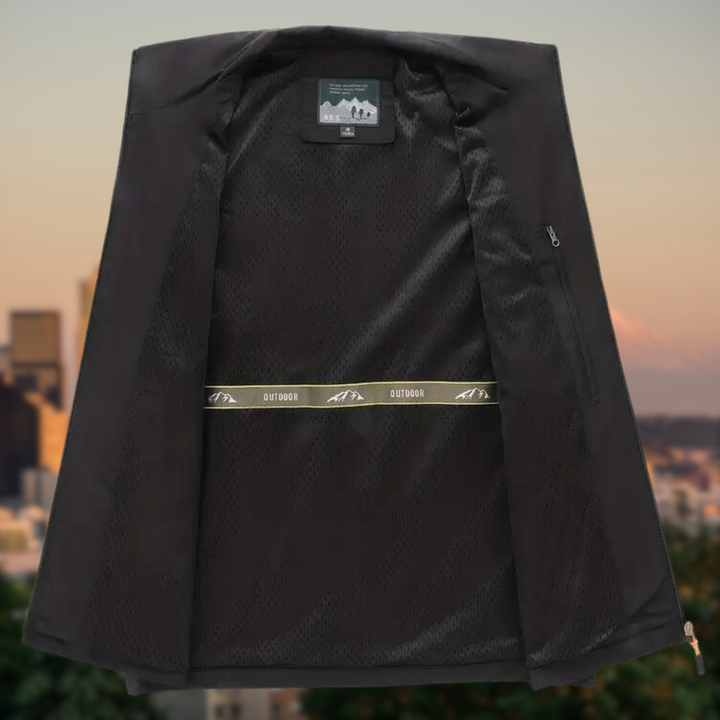 Schwarze Outdoor-Jacke, geöffnet, mit Innenfutter und Reißverschlusstasche, vor Stadtlandschaft.