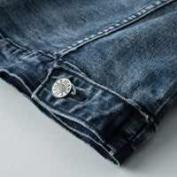 Dunkelblaue Jeansstoff-Detailaufnahme mit Knopf, robuste Denim-Textur, modische Bekleidung.