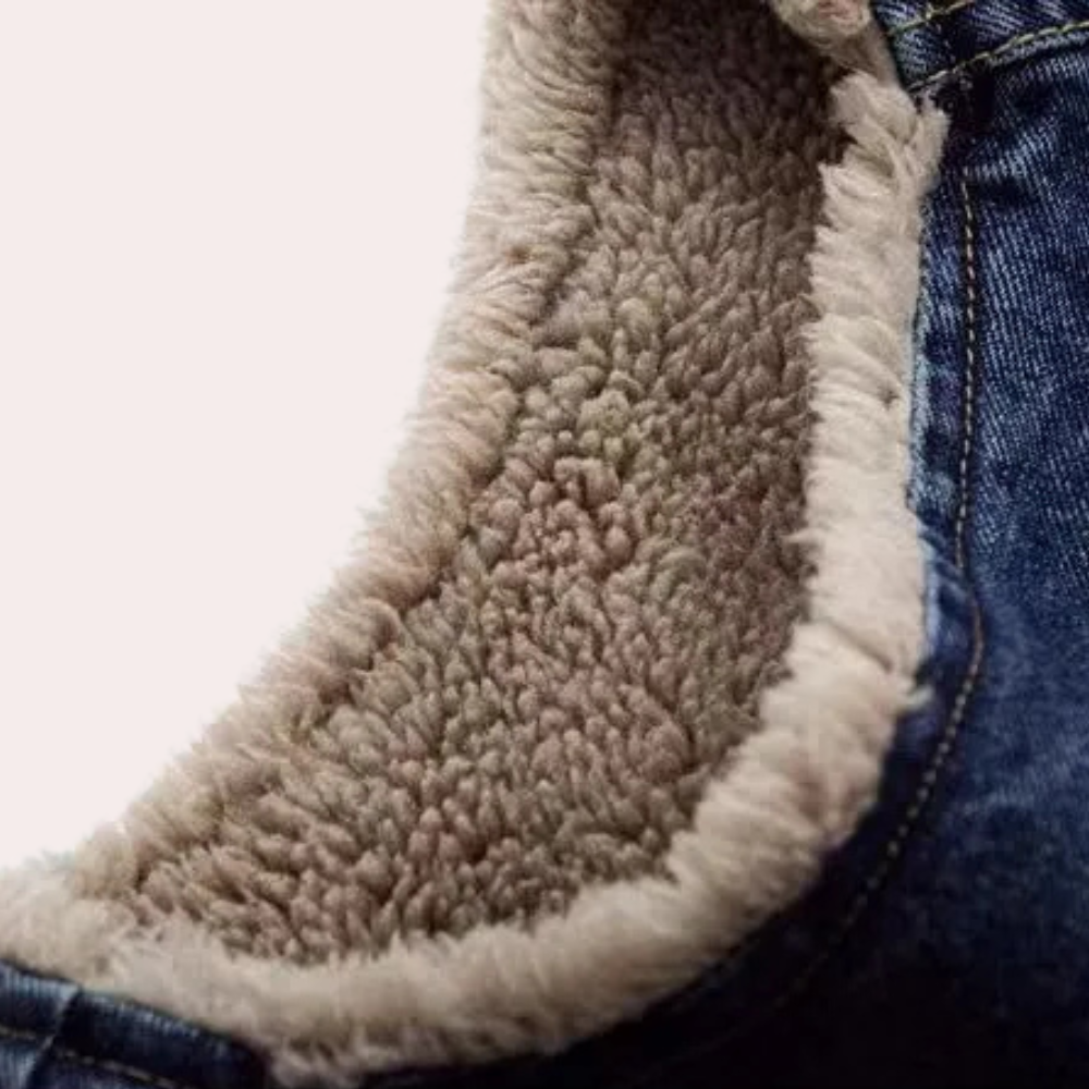 Nahaufnahme einer blauen Jeansjacke mit weichem, beigem Fleecefutter, warm und modisch.