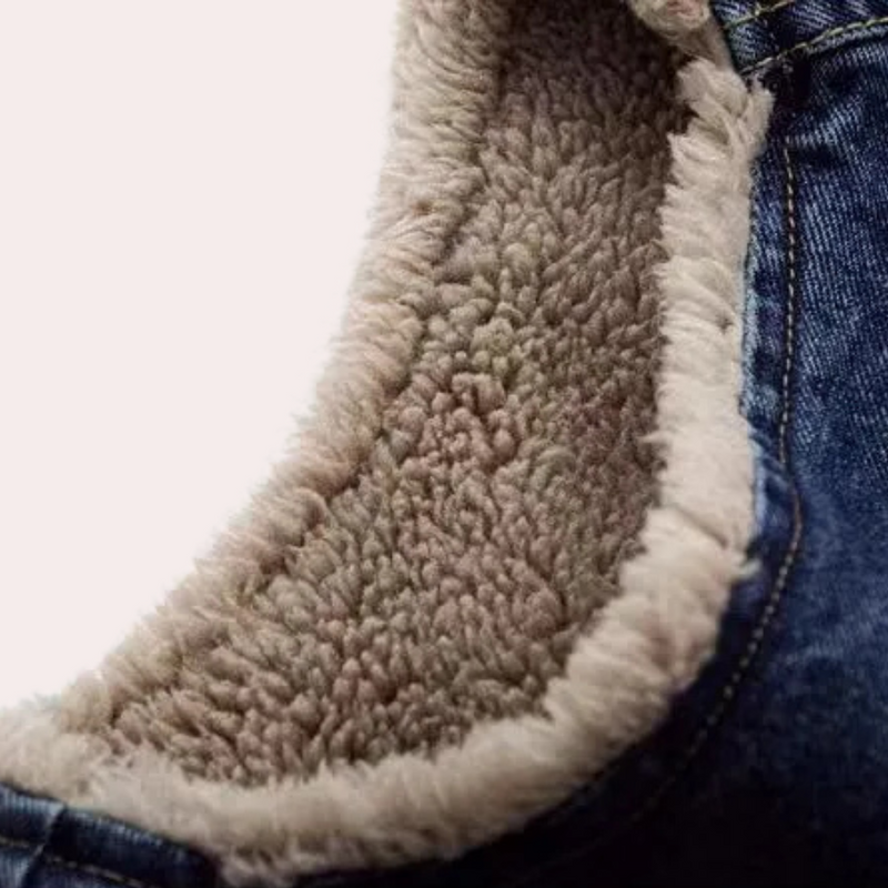 Nahaufnahme einer blauen Jeansjacke mit weichem, beigem Fleecefutter, warm und modisch.