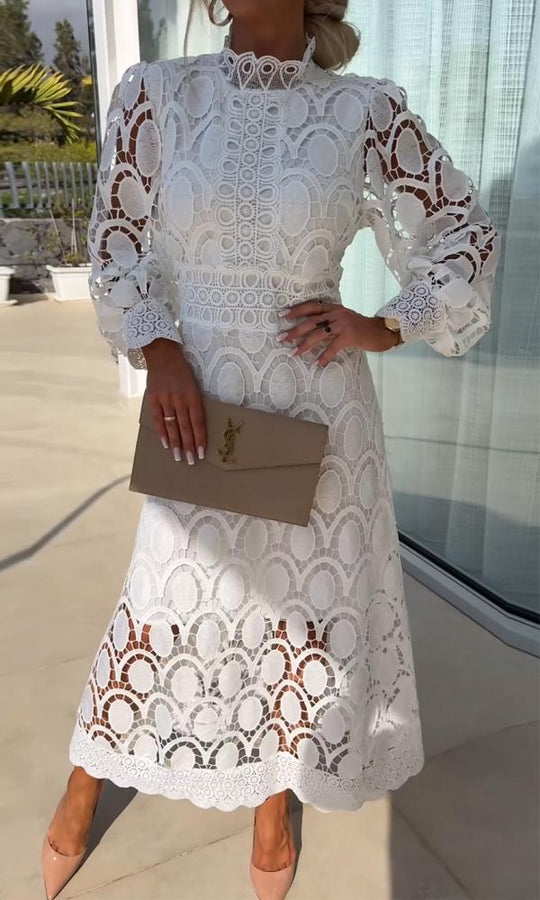 Frau in weißem Spitzenkleid mit beiger Clutch, elegantes Outfit für Sommerveranstaltungen.