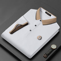 Weißes Herren-Poloshirt mit beigem Kragen, Knopfleiste und Logo, elegant gefaltet.
