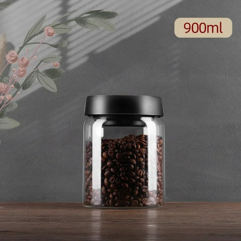 Glasbehälter 900ml mit schwarzem Deckel, gefüllt mit Kaffeebohnen, auf grauem Hintergrund.