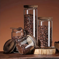 Glasbehälter mit Kaffeebohnen, Holzdeckel, brauner Hintergrund, Küchendekoration, Vorratsglas.