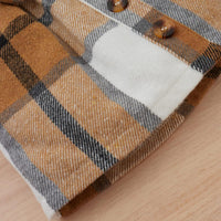 Braunes kariertes Hemd aus Baumwolle mit Knöpfen, Nahaufnahme, modisches Design.