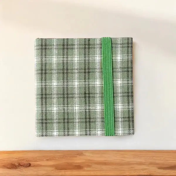 Grünes kariertes Notizbuch mit Gummiband, Hardcover, A5-Format, ideal für Büro und Schule.