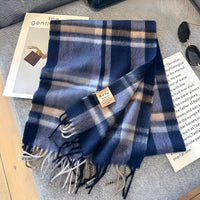 Blauer karierten Schal aus Wolle mit Fransen, modisches Accessoire auf Tisch.