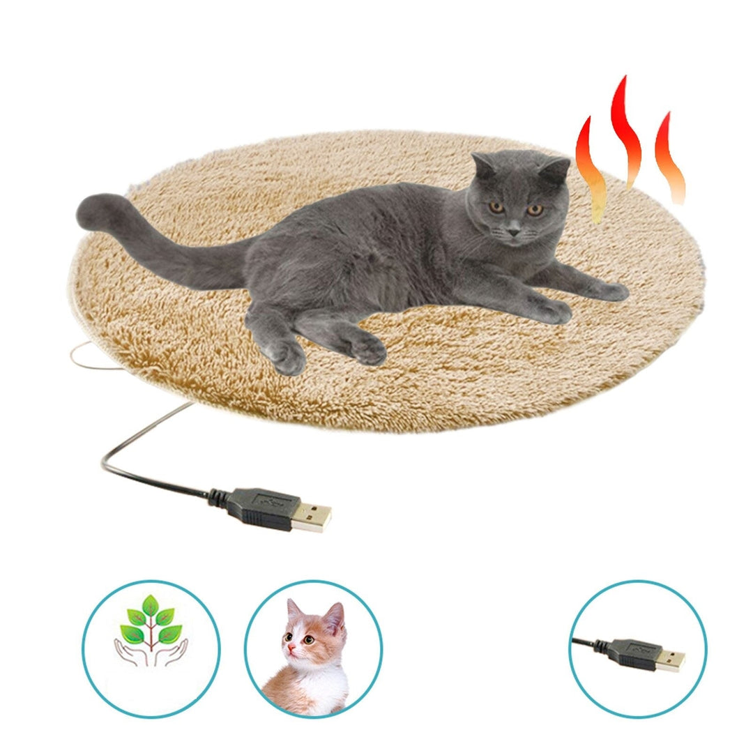 Graue Katze auf rundem, beigem Heizkissen mit USB-Anschluss, ideal für Haustiere.