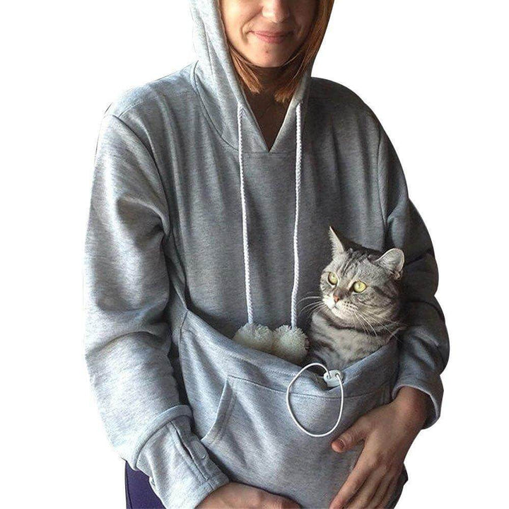 Frau in grauem Hoodie mit Kängurutasche, hält Katze; gemütlicher Pullover für Haustierbesitzer.