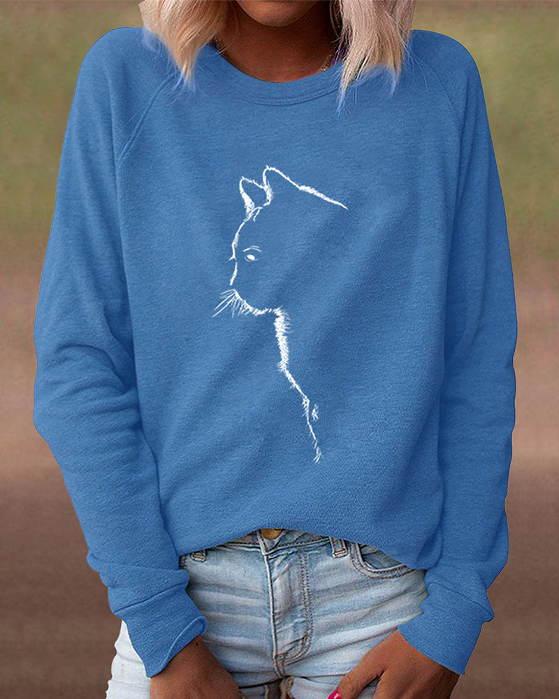Frau trägt blauen Pullover mit Katzenmotiv, lässige Damenmode, Baumwolle, Langarm.