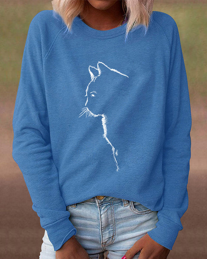 Frau trägt blauen Pullover mit Katzenmotiv, lässige Damenmode, Baumwolle, Langarm.
