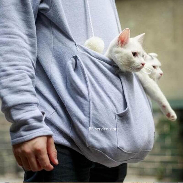 Person in grauem Hoodie mit zwei weißen Katzen in der Bauchtasche, gemütlich, ideal für Katzenliebhaber.