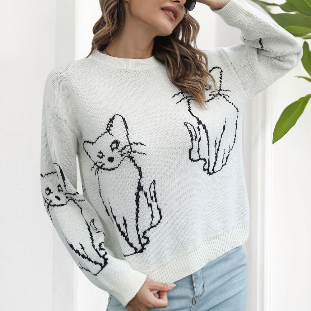 Frau trägt weißen Pullover mit Katzenmotiv, lässig, modisch, Strick, Damenmode, Herbst.