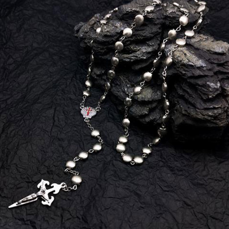 Silberne Rosenkranzkette mit Kreuzanhänger auf schwarzem Hintergrund, religiöser Schmuck.