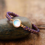 Handgemachtes Amethyst-Opal-Yoga-Armband, lila, Boho-Stil, auf Stein liegend.